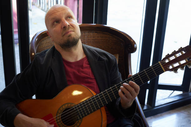 istock Acoustic guitarist demonstrates musical expression during indoor performance 1491822224
