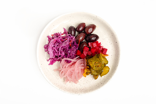 Plate with different pickles. Olive, onion, cabbage, cucumber.