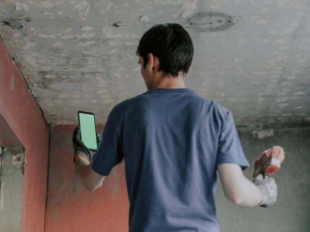 istock A young caucasian guy holds a mobile phone with a green screen and a construction brush 1491826352