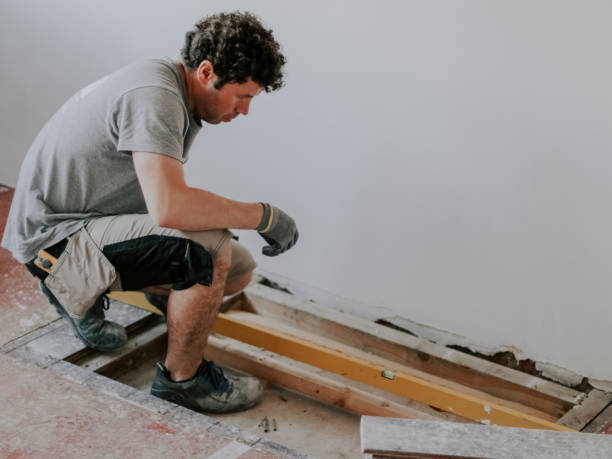 istock Young caucasian construction worker measures the space for a fireplace with a long level 1491826358