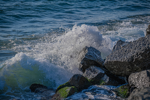 waves crashing on rocks by the sea.