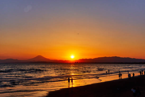 istock Scenic view of ocean with silhouette people standing against dramatic sky during sunset 1491852744