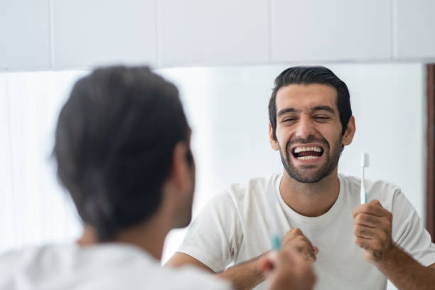 istock Reflection of man holding tooth brush laughing with himself. 1491864884