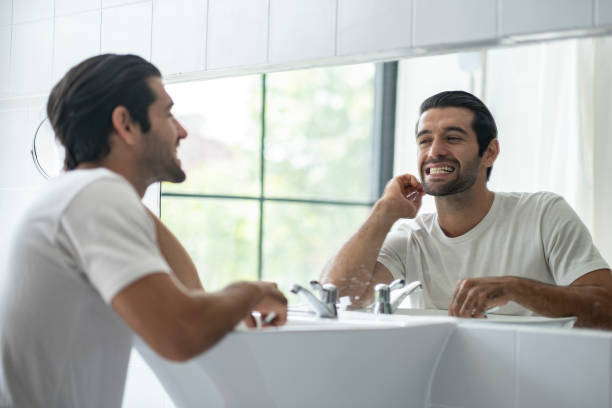 istock Arub man looking in mirror to check cleaness of brush. 1491864892