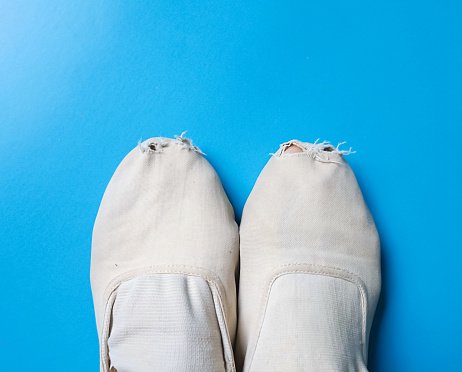 Feet wearing dance shoes on blue background