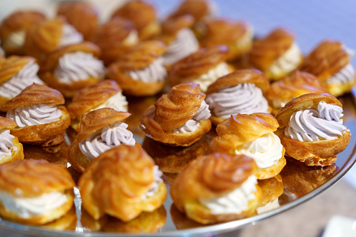 A close-up shot showcases cream puffs arranged on a serving tray.