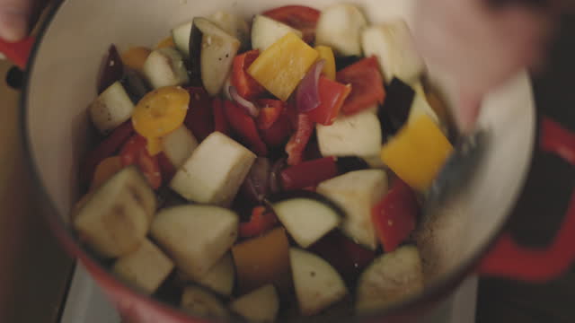 cooking chopped aubergine, pepper, and onion together