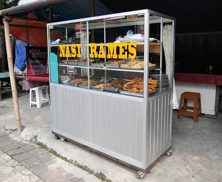 Bandung, West Java, Indonesia - May 17, 2023. An Indonesian street food cart typically found at the side of the street selling instantly cooked food. This one offers nasi rames or mixed rice with many assorted kinds of local Indonesian food.