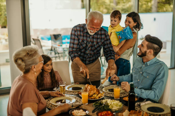 istock Happy multi-generation family gathering around dining table and having fun during a lunch. 1491872315