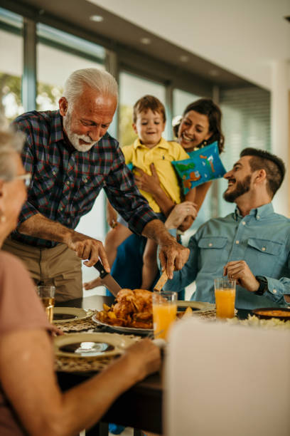 istock Happy multi-generation family gathering around dining table and having fun during a lunch. 1491872452