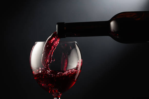 istock Pouring red wine into a wine glass. 1491874276