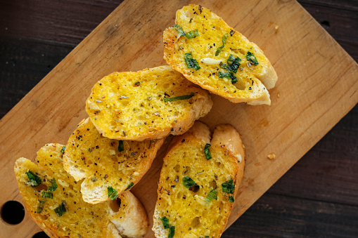 freshly toasted garlic bread on a white plate.