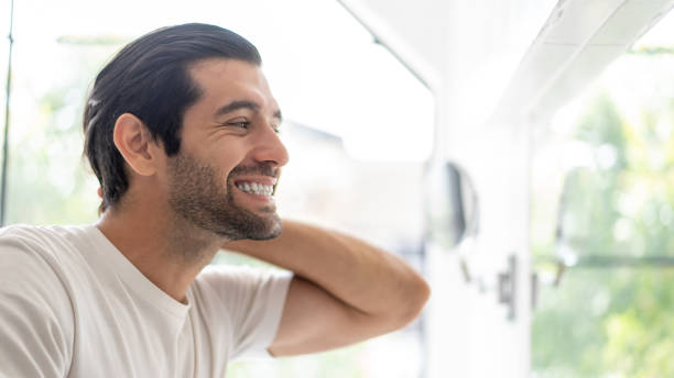 istock Man with toothbrush cleaning teeth and looking to mirror at home bathroom. 1491875573