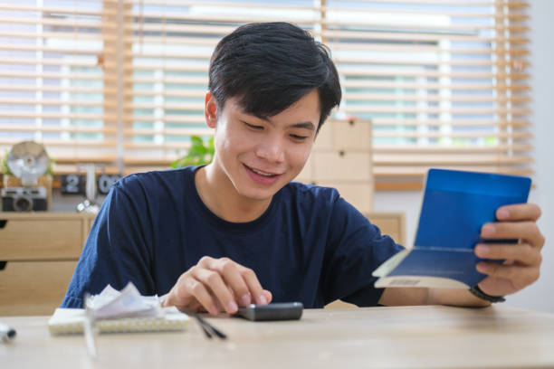 istock Man using calculator and counting money and making notes at home. Investment business, retirement, finance and saving money for future concept. 1491879054