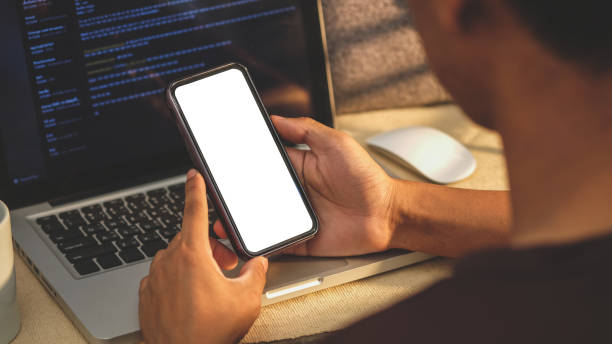 istock Over shoulder view of young man holding smart phone with blank screen. 1491879082