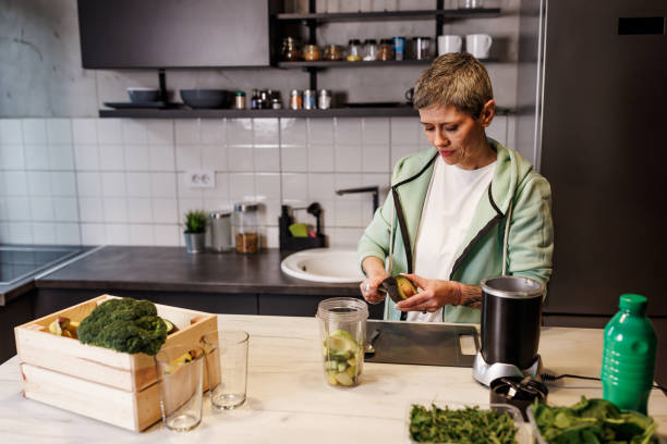 istock Mature woman cutting up fruit for a smoothie at home 1491883209