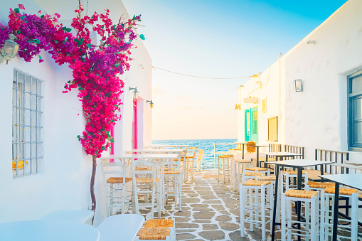 Naoussa typical white street leading to sea with sunshine, small village on Paros island, Greece