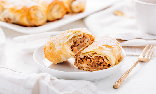 Homemade apple strudel with cinnamon, apple pie with cup of fruit tea