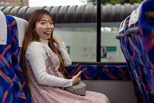 Woman moving to airport using airport shuttle - looking at camera