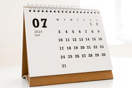Hand with pen mark at 15th on calendar date