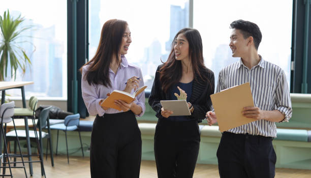 istock Collaborative process of young asian business people team working together discussing, researching, brainstorming and planning work at business meeting in modern office building and city background 1491887605