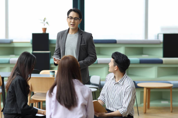 istock Collaborative process of young asian business people team working together discussing, researching, brainstorming and planning work at business meeting in modern office building and city background 1491887622