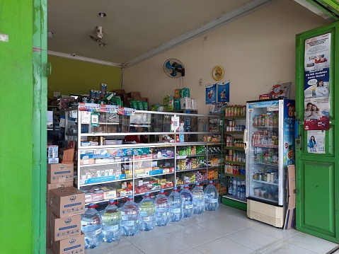 Purwokerto, Indonesia - March 2023 : Front view of a small store that sells various kinds of drinks and medicines in glass windows, showcases and iron shelves