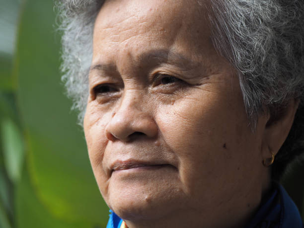 istock Senior woman looking up with a smile while standing outdoors. 1491892310