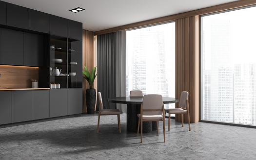 Corner of stylish kitchen with gray and wooden walls, concrete floor, gray cabinets, cupboard and round dining table with chairs. 3d rendering