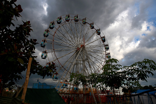 A Ferris wheel is an amusement ride consisting of a rotating upright wheel with multiple passenger-carrying components attached to the rim in such a way that as the wheel turns, they are kept upright, usually by gravity.