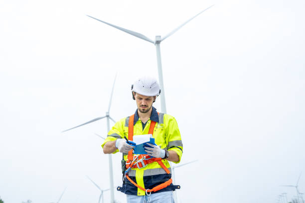 istock Maintenance engineer man working in wind turbine farm. 1491894796