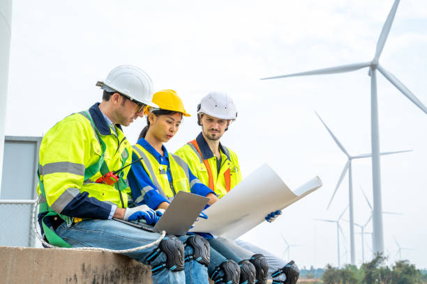 istock Engineer man looking and checking wind turbines at field,Wind turbine farm. 1491894886