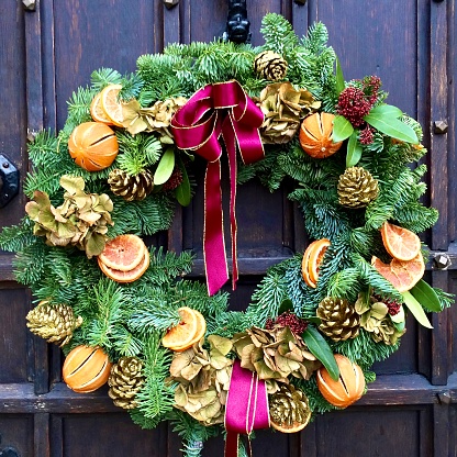 An autumn or fall wreath decoration on a vintage green door