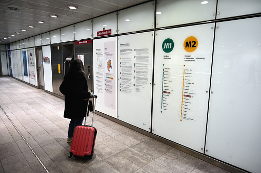 Copenhagen, Denmark, may 8, 2023 : Woman in front of information board at Christianshavn metro station in Copenhagen Denmark