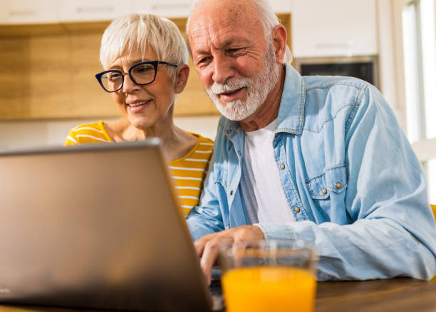 istock Senior couple looking at laptop at home 1491944097