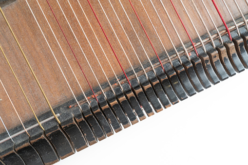 Top horizontal studio shot of vintage, old wooden zither isolated on white background. Detail of zither strings creates abstract pattern