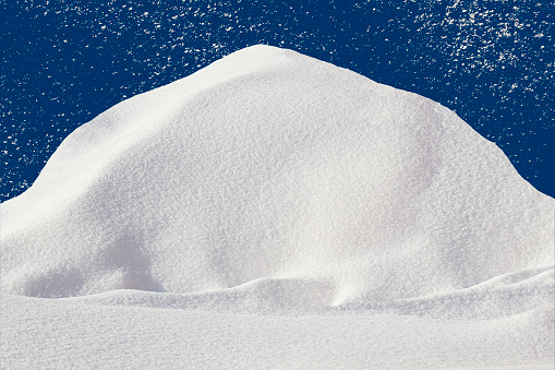 Pile of snow with copy space on blue background with falling snow texture. Winter mockup concept