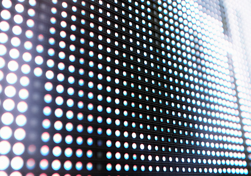 Abstract close-up view of a modern electronic billboard with pixels made up by light-emitting diodes.