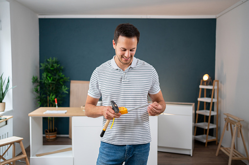 Portrait of young Caucasian handyman, renovating his new apartment