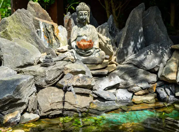 Photo of buddha statue in the stone rock garden