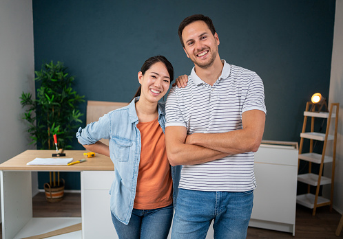Portrait of young multiracial couple, in their new apartment during renovation process