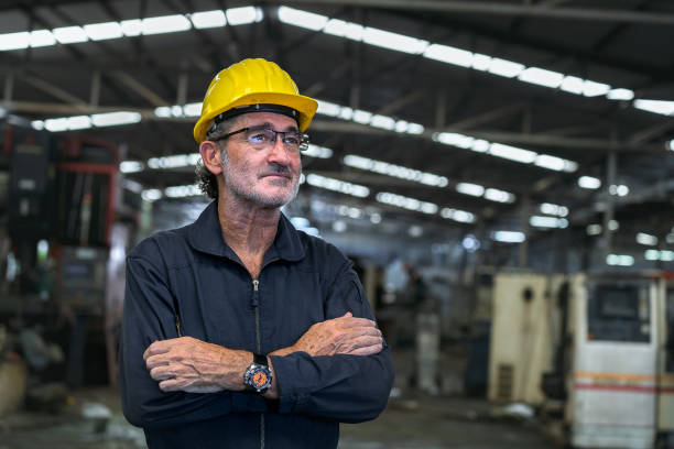 istock Engineer, technician or senior foreman Standing with arms crossed, smart man smiles like an executive. with the background being an industrial factory warehouse 1491977760