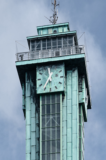 Detail vertical shot of big clock on the top of the tower of Ostrava New City Hall. Steel construction with copper sheathing