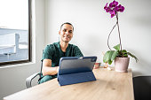 Portrait of a mid adult dentist man using tablet at medical clinic