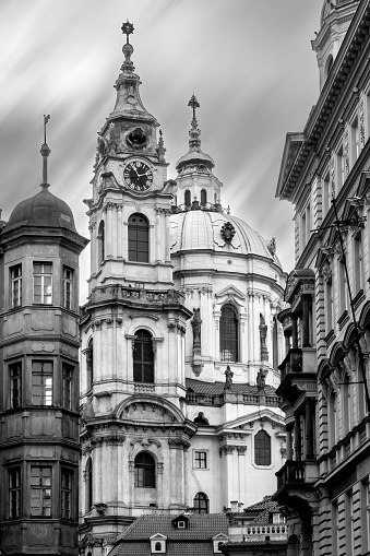 Black and white vertical shot of historical St.Nicholas church in the historical center of Prague. Beautiful medieval religious architecture. Mala Strana disctrict
