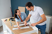 Young multiracial couple together assembling drawers for kitchen cabinets