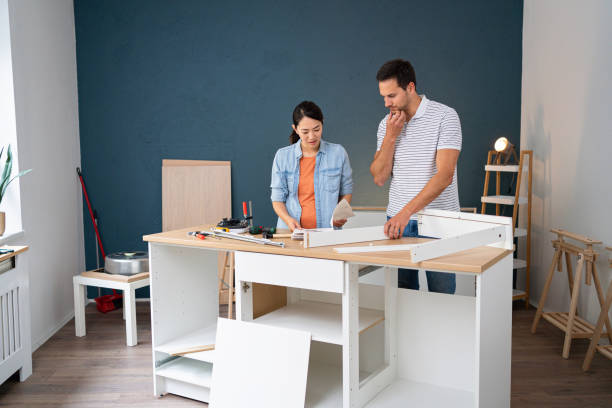 istock Multiracial couple reading instruction manual while assembling furniture 1491986739