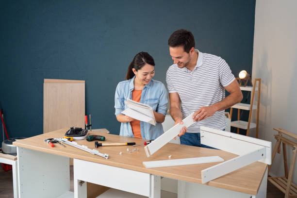 istock Multiracial couple reading instruction manual while assembling furniture 1491986758