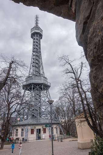 Prague, Czechia - 03.24.2023: Vertical shot of Petrin Lookout Tower with people walking by