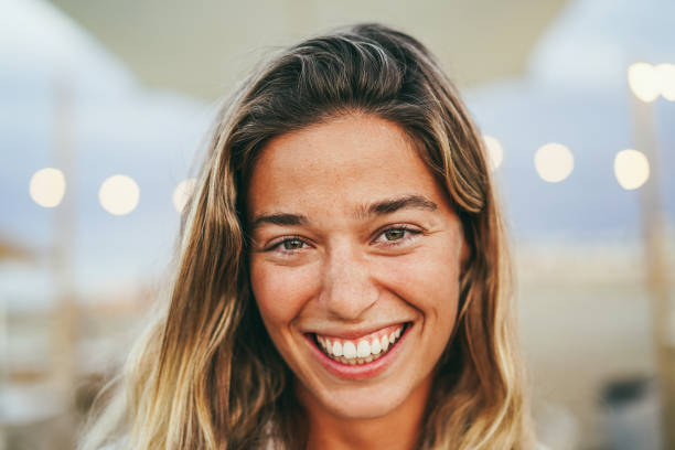 istock Young girl smiling on camera with beach bar on background - Main focus on right eye 1491987216